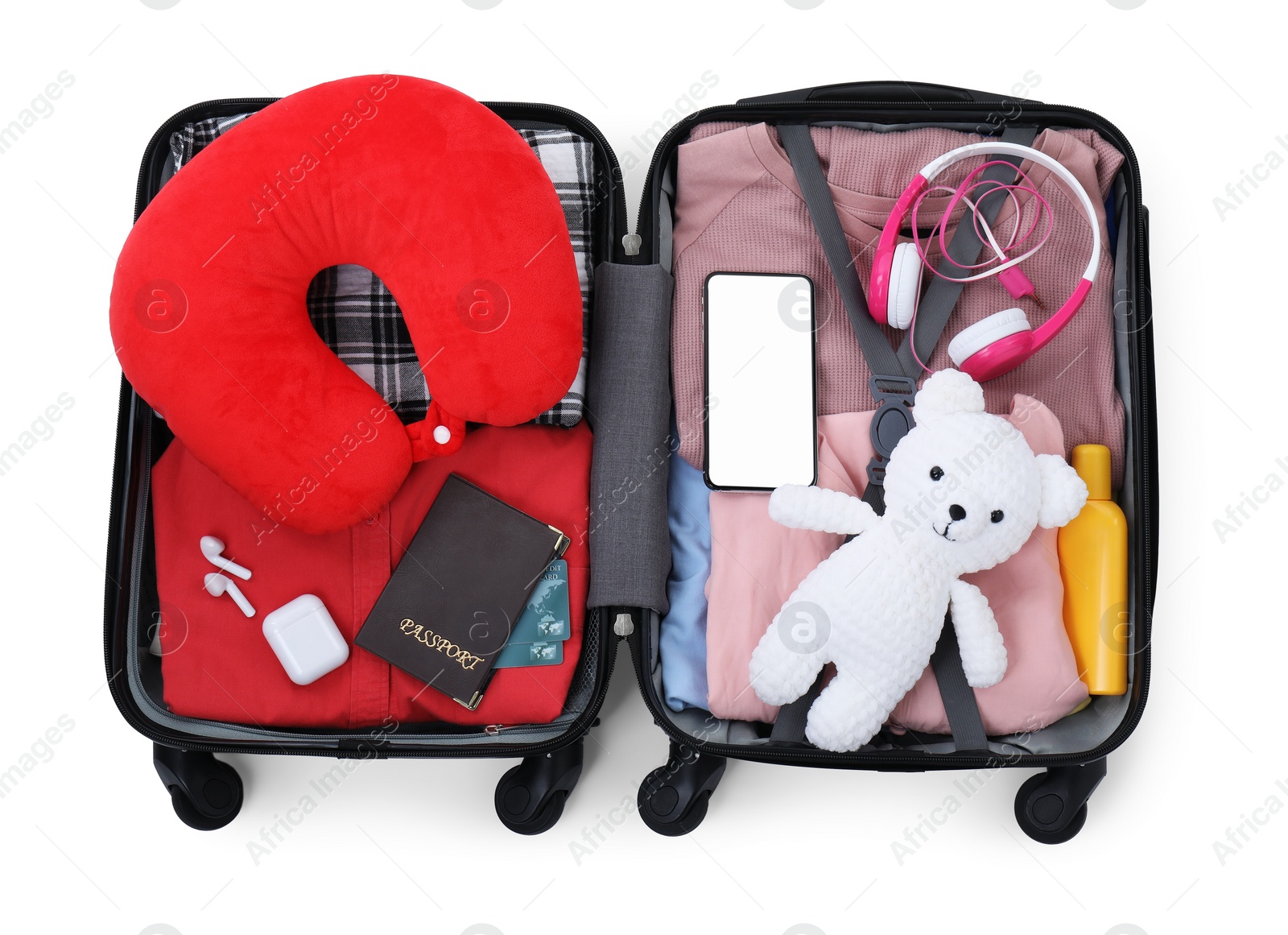 Photo of Soft travel pillow, hat, passports and other items in open suitcase isolated on white, top view