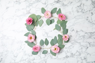 Fresh eucalyptus leaves with flowers and space for design on marble background, flat lay