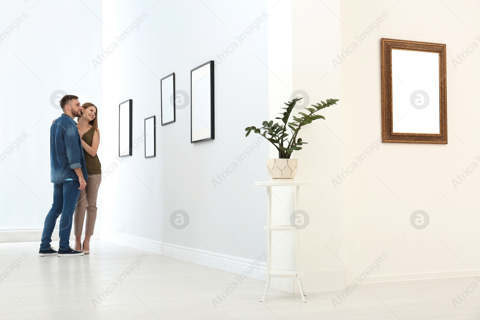 Photo of Young couple viewing exposition in modern art gallery