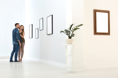 Young couple viewing exposition in modern art gallery