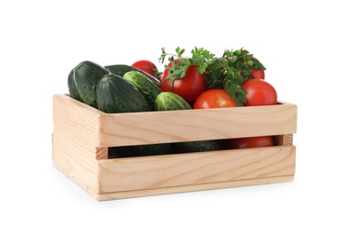 Wooden crate full of fresh vegetables on white background