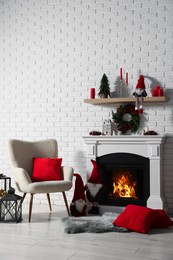 Photo of Beautiful Christmas themed photo zone with armchair and fireplace in room