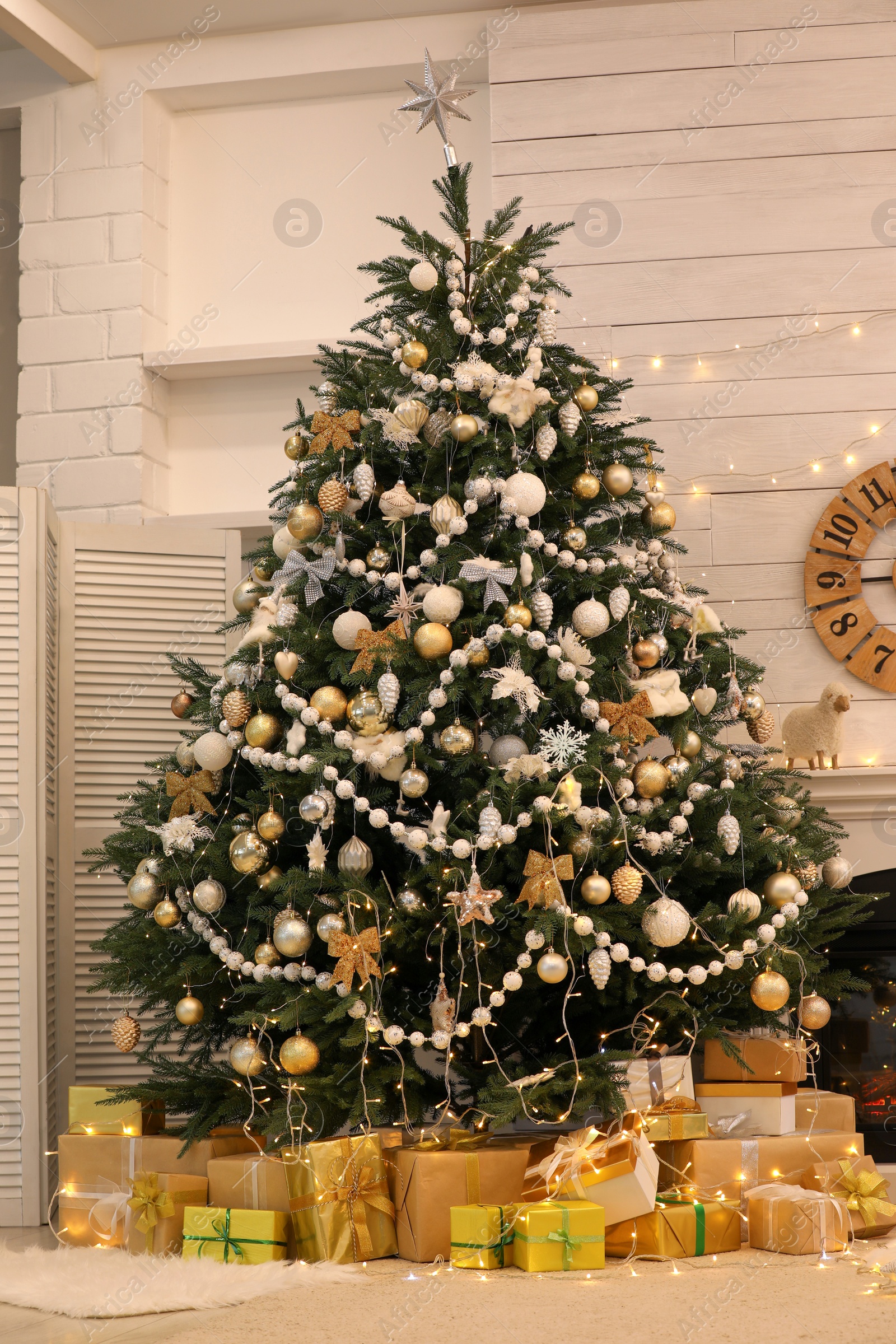 Photo of Decorated Christmas tree with gift boxes in room