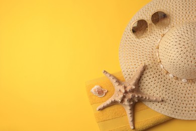 Photo of Beach accessories, shell and starfish on orange background, flat lay with space for text