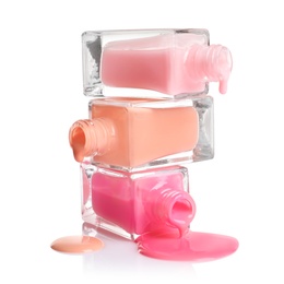 Photo of Spilled different nail polishes with bottles on white background