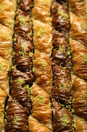 Photo of Delicious sweet baklava with pistachios as background, closeup view