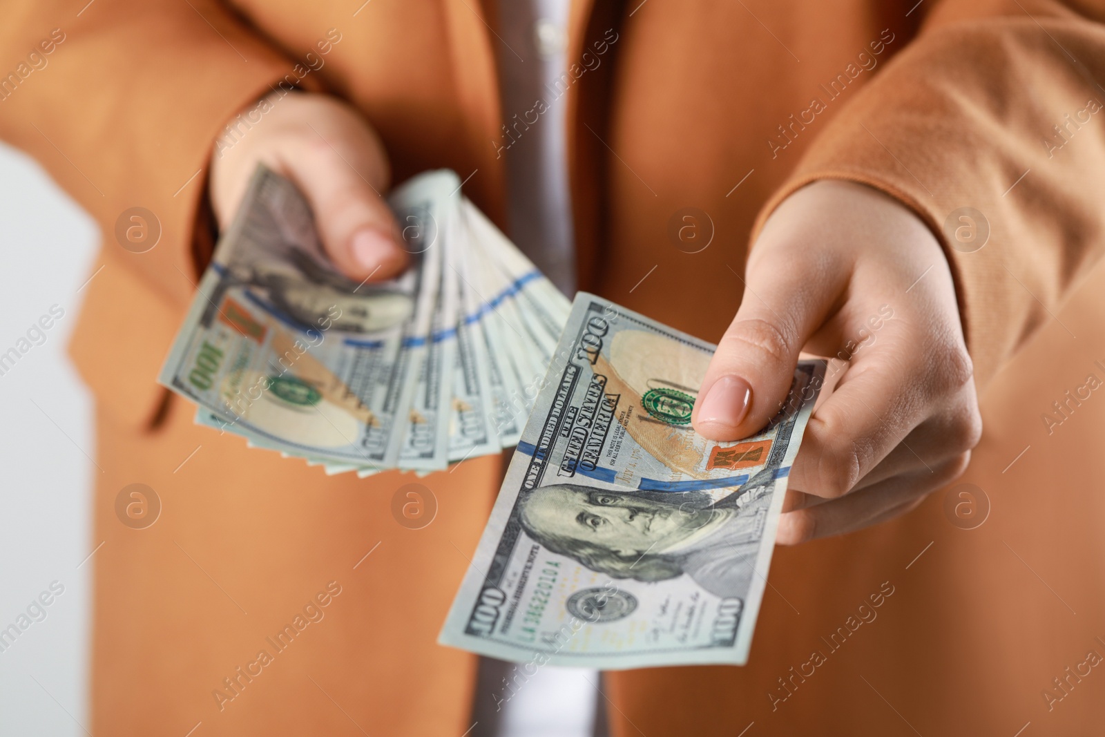 Photo of Woman holding dollar banknotes on white background, closeup. Money exchange concept