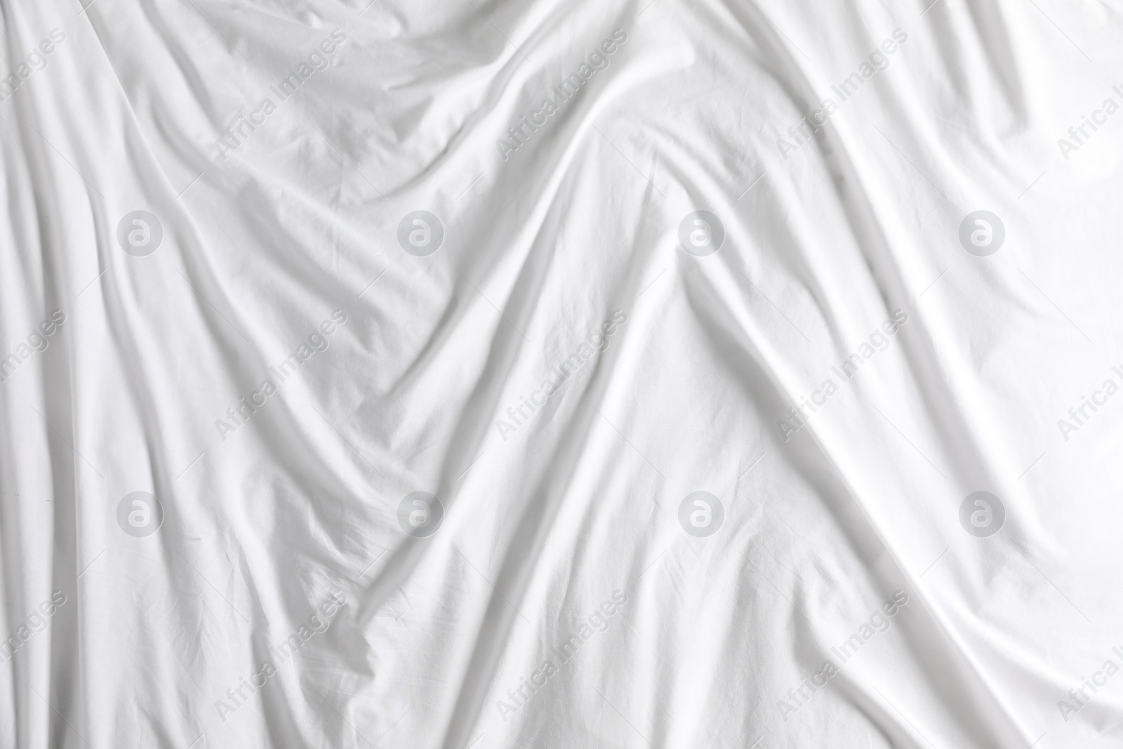 Photo of Crumpled white fabric as background, top view