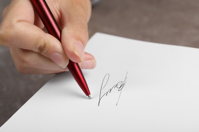 Writer signing autograph in book at table, closeup