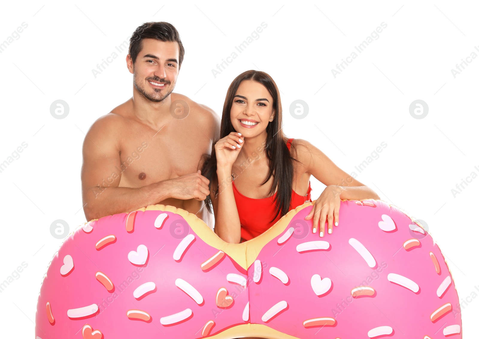 Photo of Young attractive couple in beachwear with inflatable ring on white background