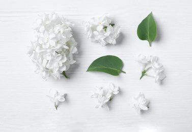 Photo of Flat lay composition with beautiful lilac blossom on white wooden background