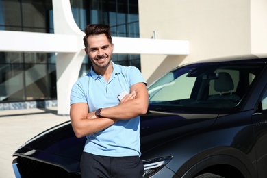 Young man near modern car on sunny day, outdoors