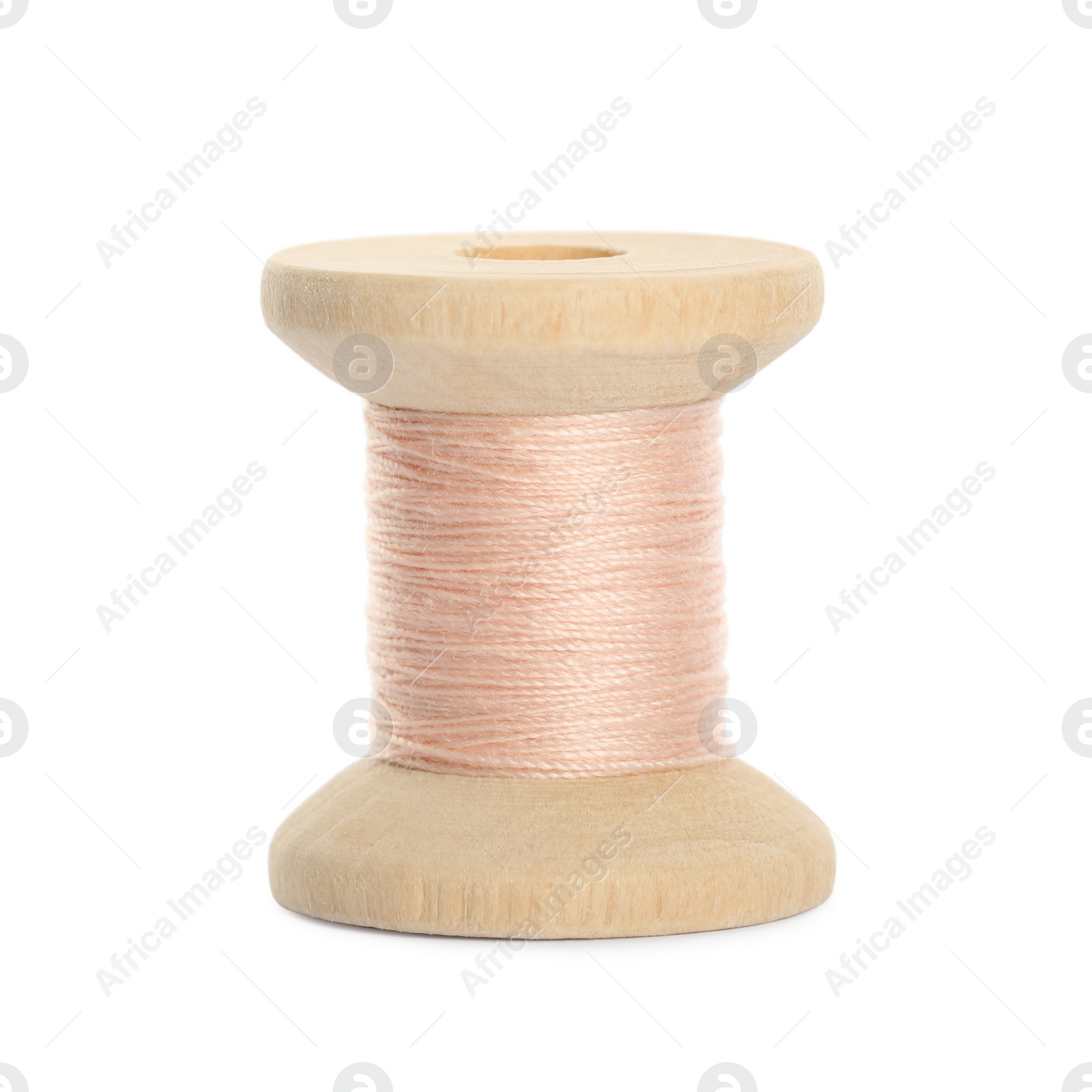 Photo of Wooden spool of pale pink sewing thread isolated on white