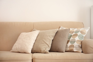 Different soft pillows on sofa in room