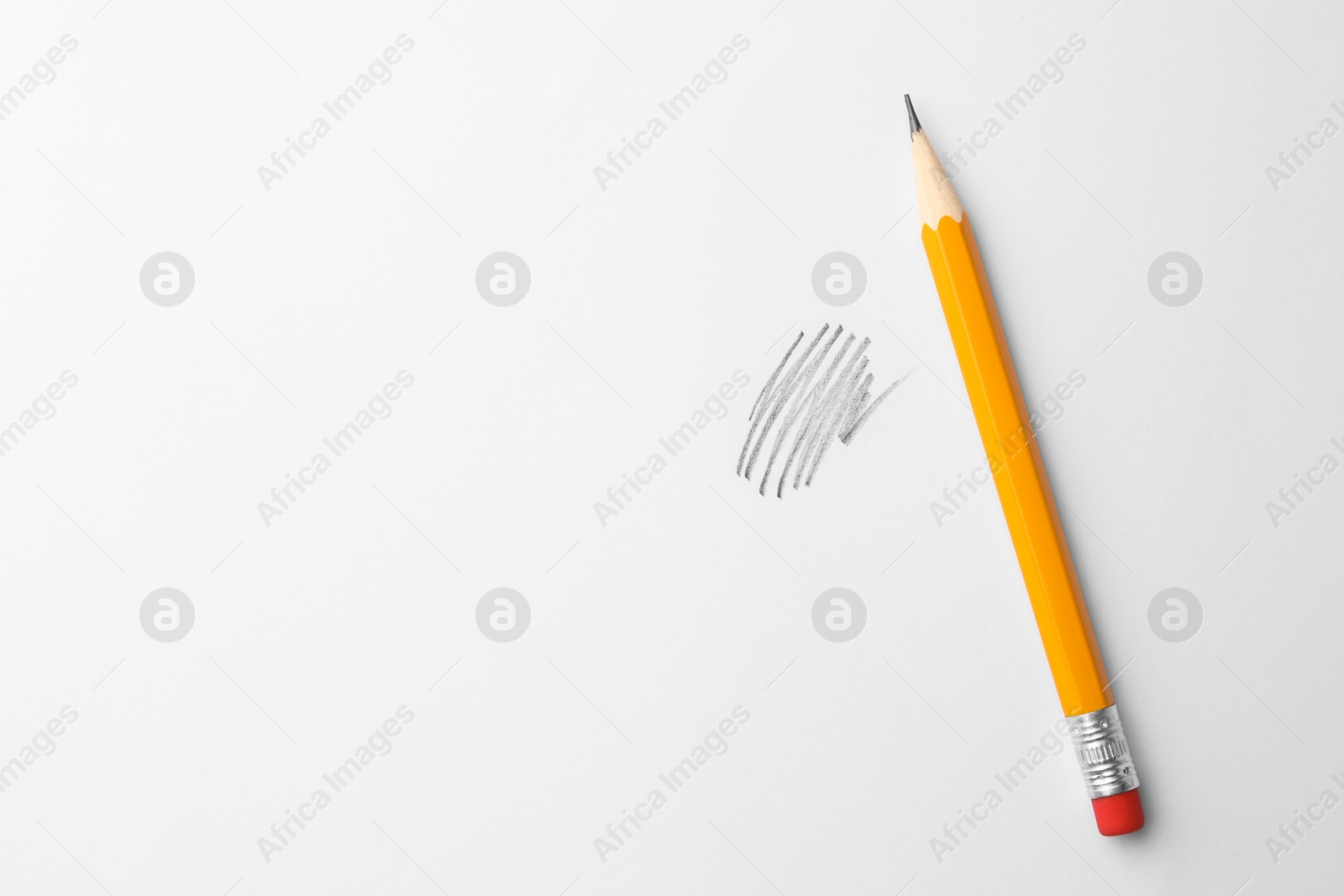 Photo of Sharp graphite pencil with eraser and hand drawn scribble on white sheet of paper, top view. Space for text