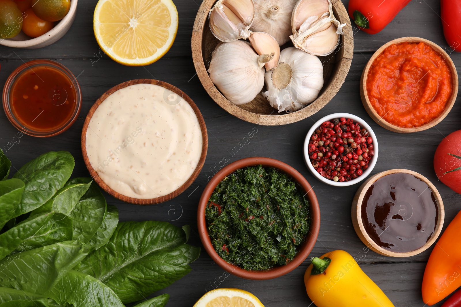 Photo of Different fresh marinades in bowls and ingredients on grey wooden table, flat lay