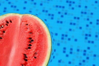 Half of fresh juicy watermelon in swimming pool, closeup. Space for text