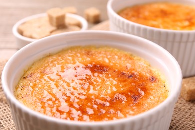 Delicious creme brulee in bowls on table, closeup