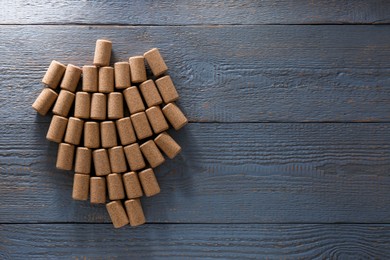 Photo of Grape made of wine bottle corks on grey wooden table, top view. Space for text