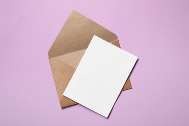Photo of Letter envelope and card on violet background, top view. Space for text