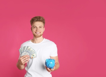 Young man with piggy bank and money on color background. Space for text