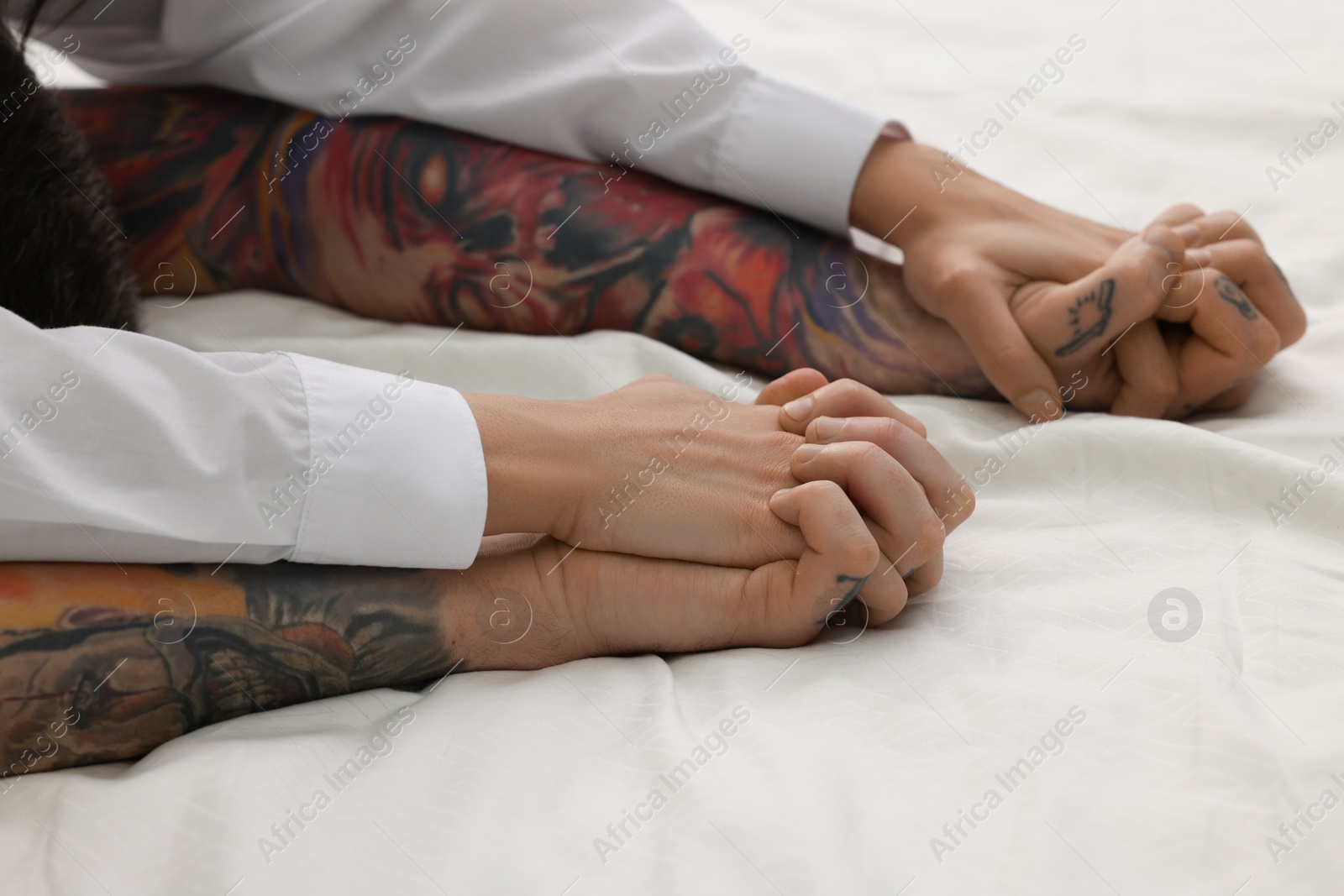 Photo of Passionate couple having sex on bed, closeup of hands