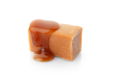 Photo of Delicious candy with caramel sauce on white background