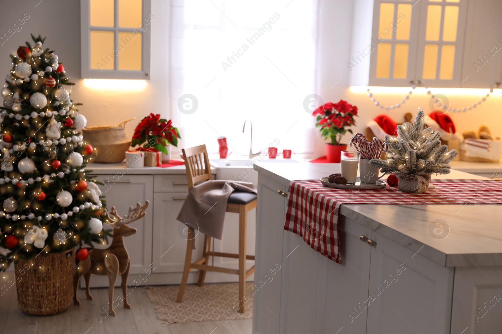 Photo of Beautiful kitchen interior with Christmas tree and festive decor