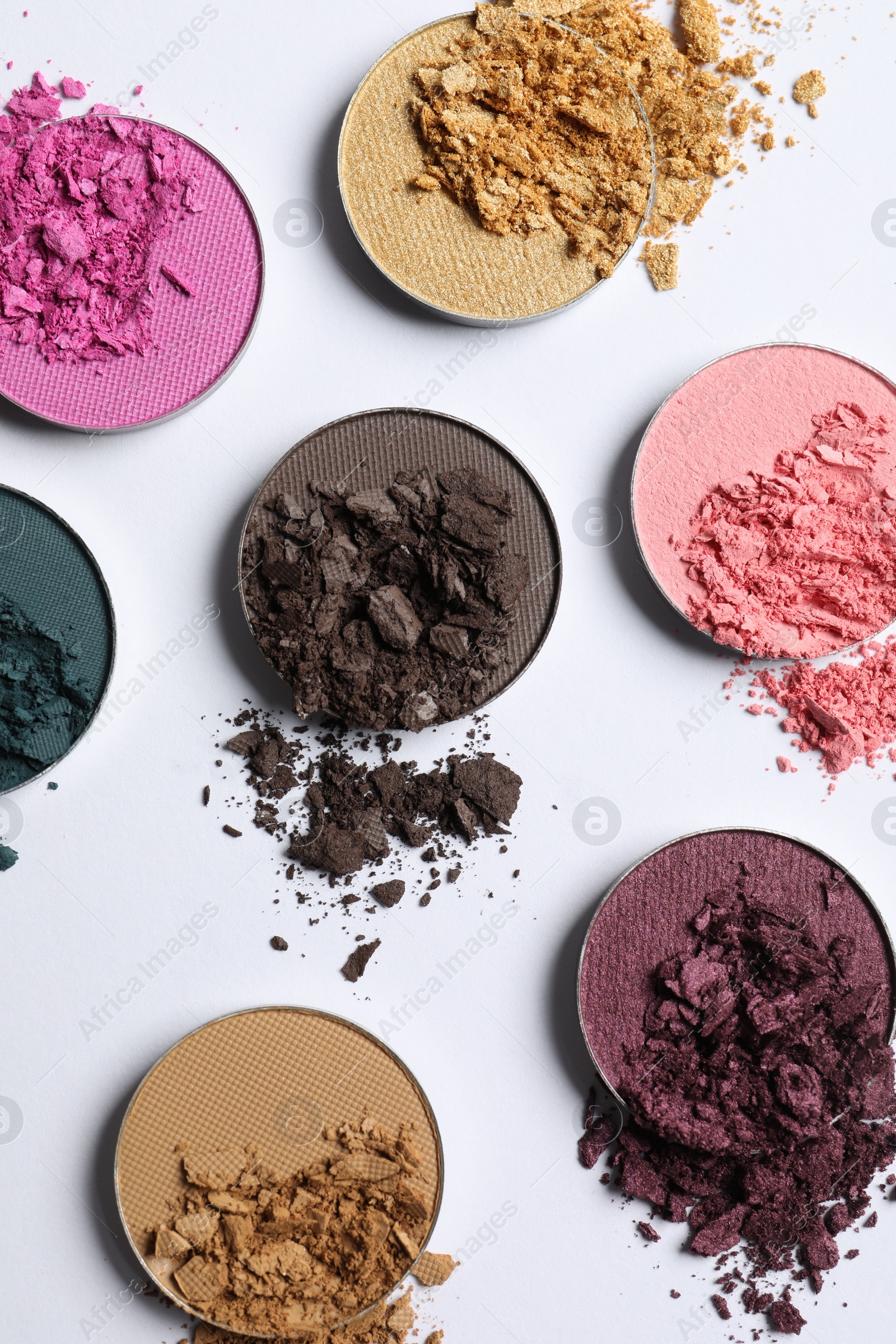 Photo of Different crushed eye shadows on white background, flat lay. Professional makeup product