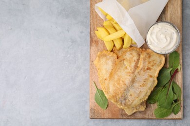 Delicious fish and chips with tasty sauce and mangold on gray table, top view. Space for text