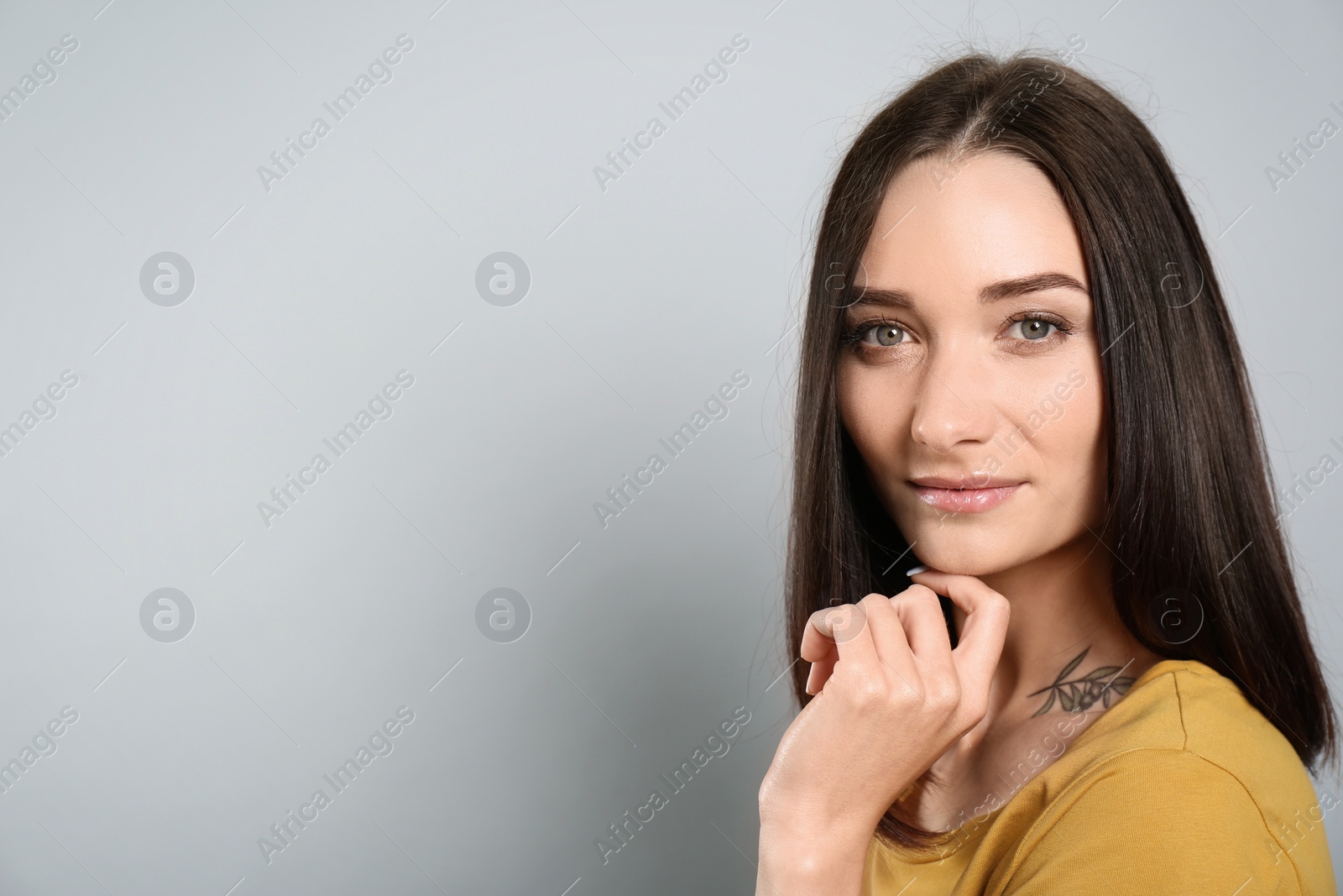 Photo of Portrait of pretty young woman with gorgeous chestnut hair on light grey background, space for text