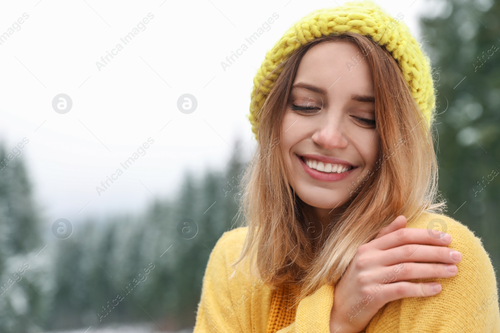 Photo of Young woman in warm clothes outdoors, space for text. Winter vacation