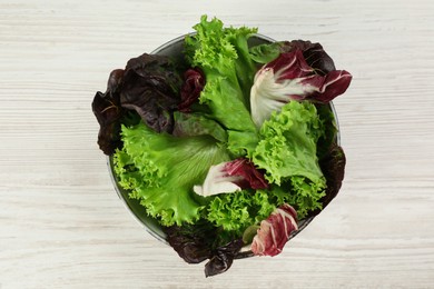 Different sorts of lettuce on white wooden table, top view