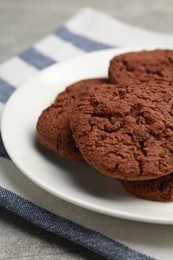 Delicious chocolate chip cookies on light grey table, closeup