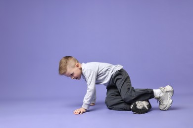 Happy little boy dancing on violet background