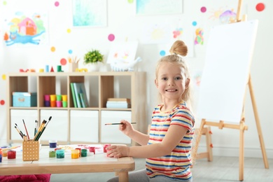 Photo of Cute little child painting at lesson indoors