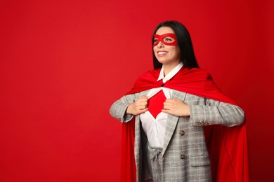 Photo of Confident businesswoman wearing superhero costume under suit on red background, space for text