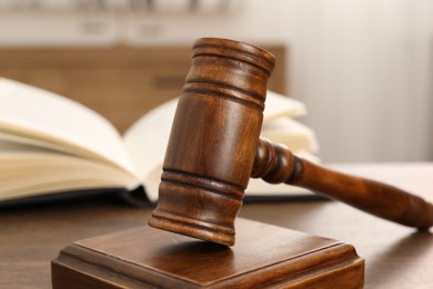 Wooden gavel and sound block on table indoors, closeup