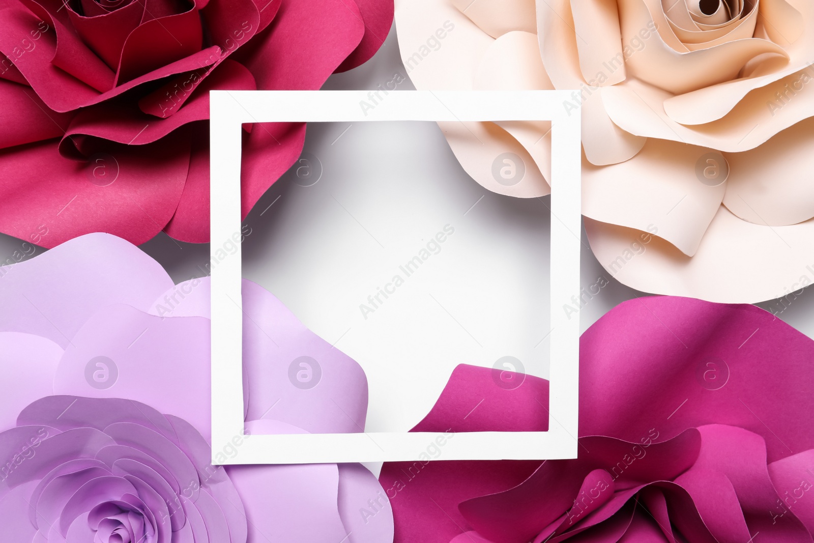 Photo of Different beautiful flowers made of paper and frame on white background, flat lay. Space for text