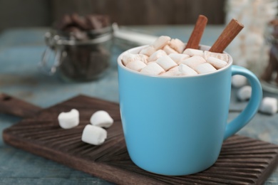 Photo of Cup of chocolate milk with marshmallows on wooden table