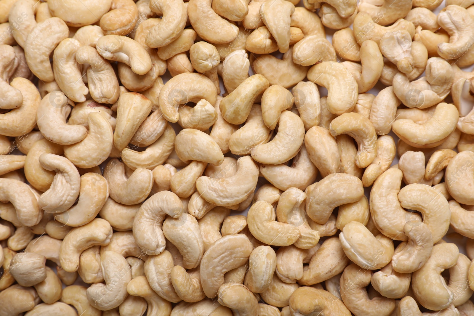 Photo of Many tasty cashew nuts as background, top view