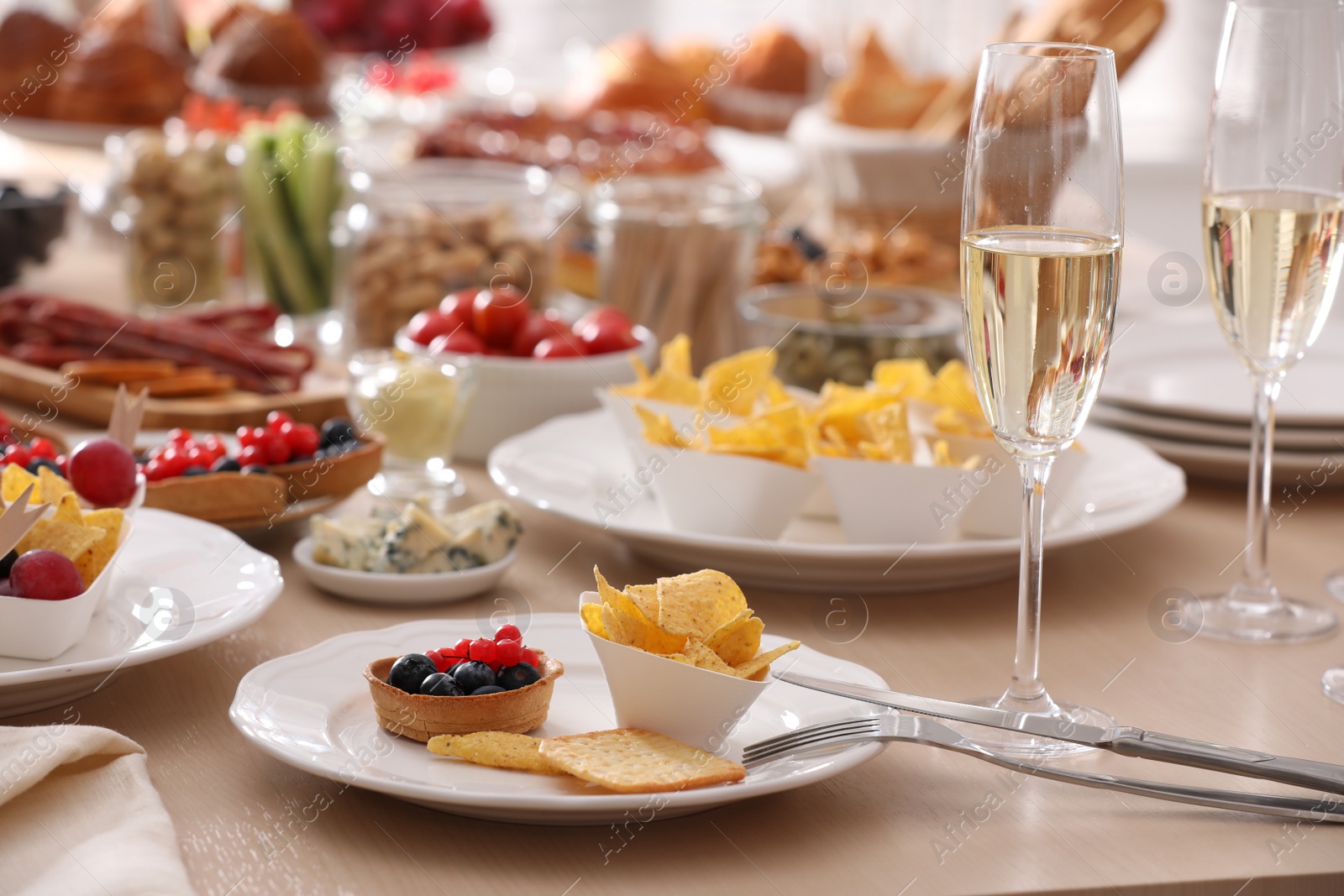 Photo of Variety of snacks on wooden table in buffet style indoors