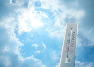 Weather thermometer and beautiful blue sky with fluffy clouds on background, space for text