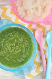 Healthy baby food. Different tasty puree in bowls on white wooden table, flat lay