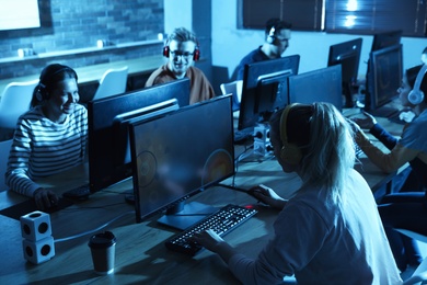 Group of people playing video games in internet cafe
