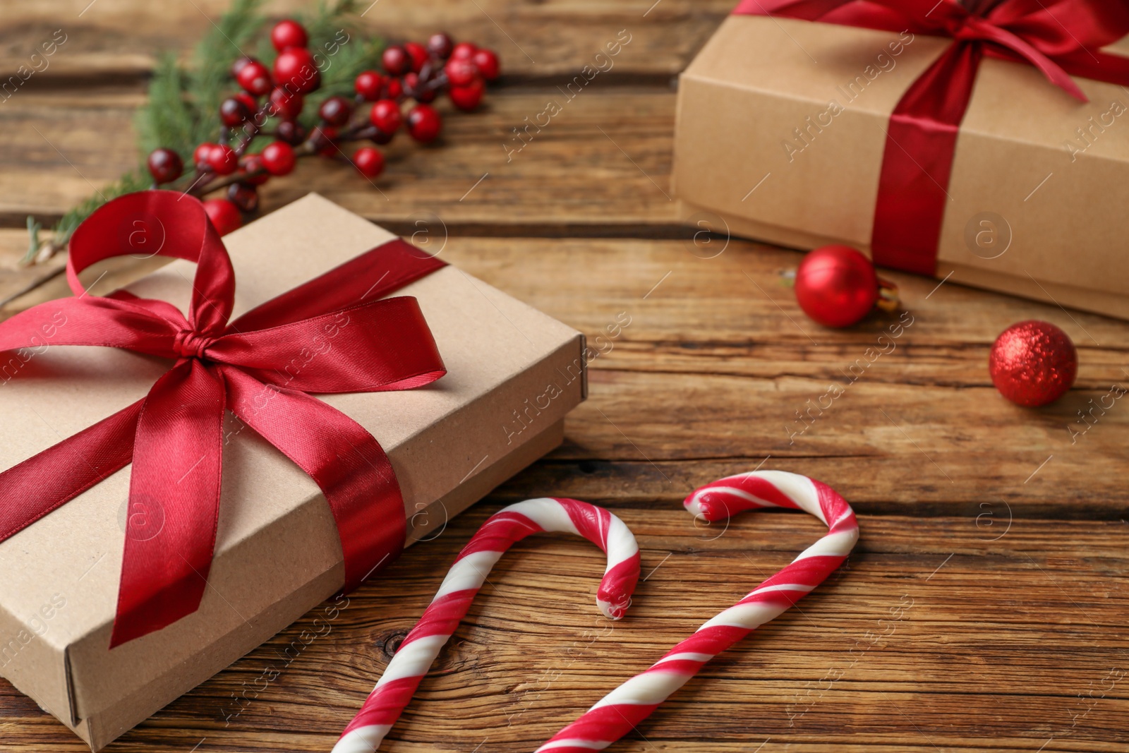 Photo of Gift boxes, candy canes and Christmas decor on wooden table