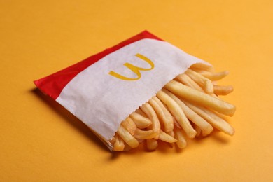 Photo of MYKOLAIV, UKRAINE - AUGUST 12, 2021: Small portion of McDonald's French fries on orange background