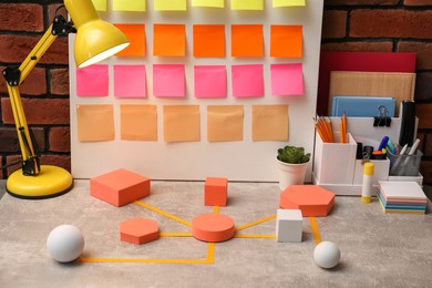 Photo of Business process scheme with geometric figures and stationery on light grey table