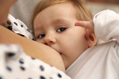 Photo of Woman breastfeeding her little baby, closeup view