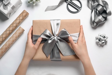 Woman with beautiful gift box on white background, top view